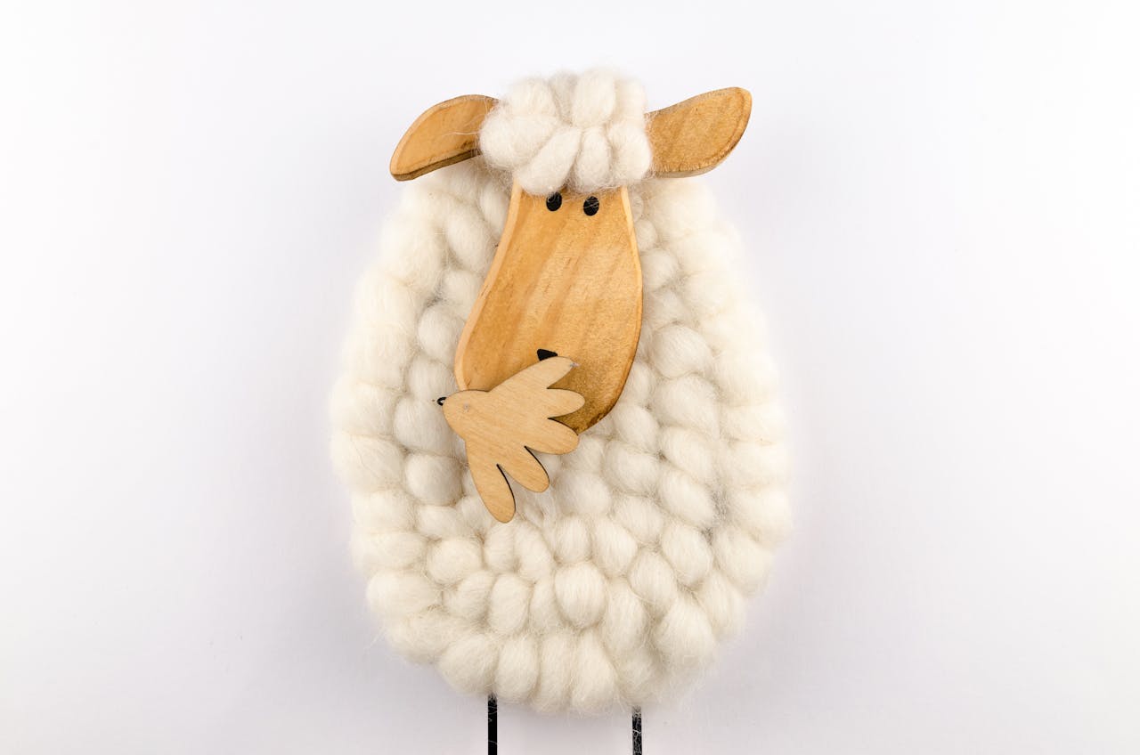 Charming sheep ornament crafted from wool and wood, perfect for decoration.